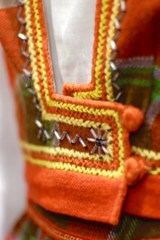 a bright orange dress with metallic hardware is worn by a little girl