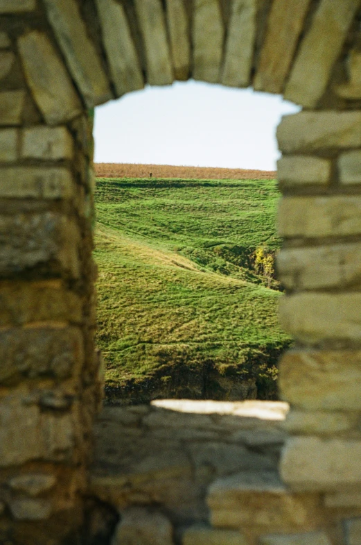 a large field behind some old brick wall