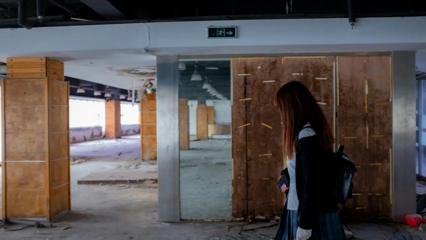 a woman walks into a building in the process of being renovated