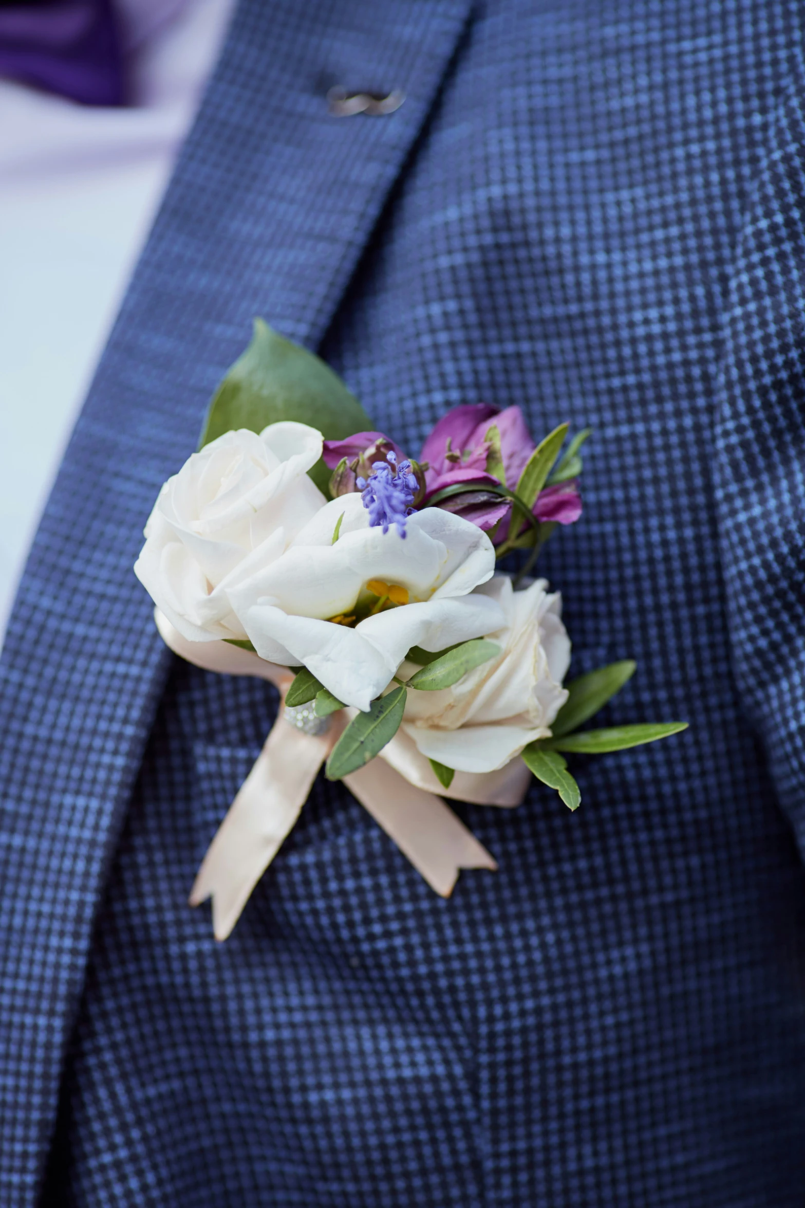 a man in a blue suit has his hand on the pocket of a boutonnier