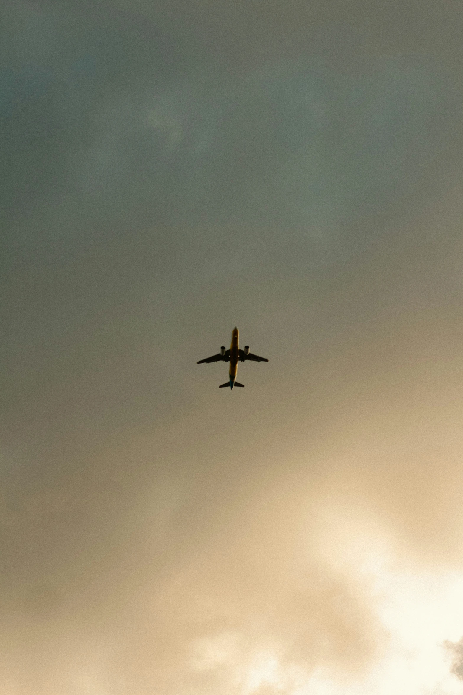 an airplane flying in the air with clouds and sky