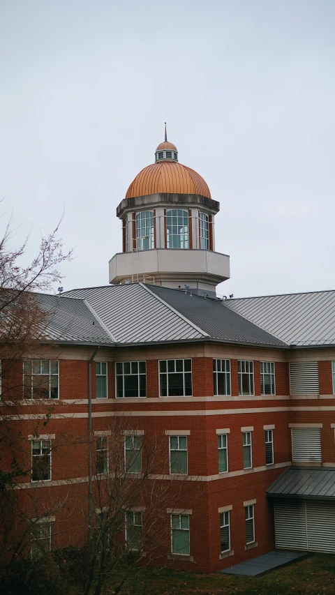 an orange and black tower is atop a tall building