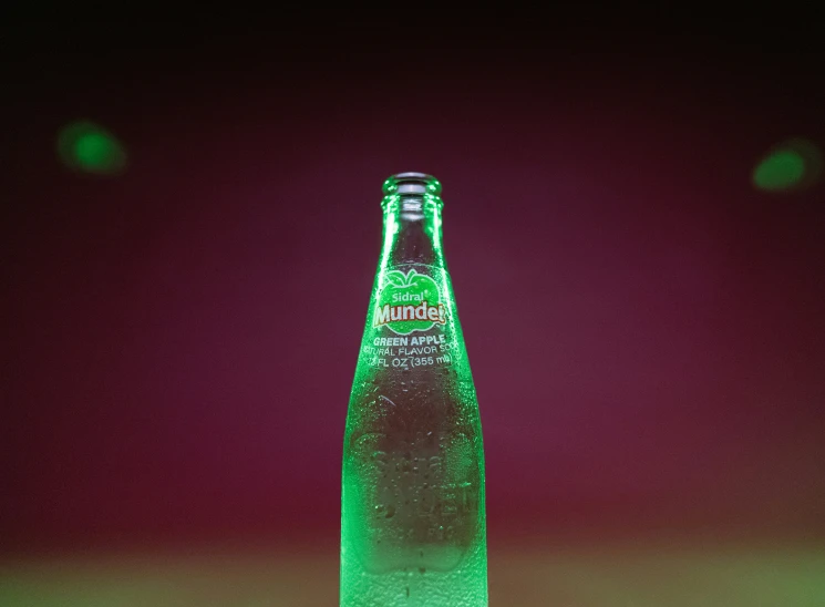 a green bottle that is sitting on a table