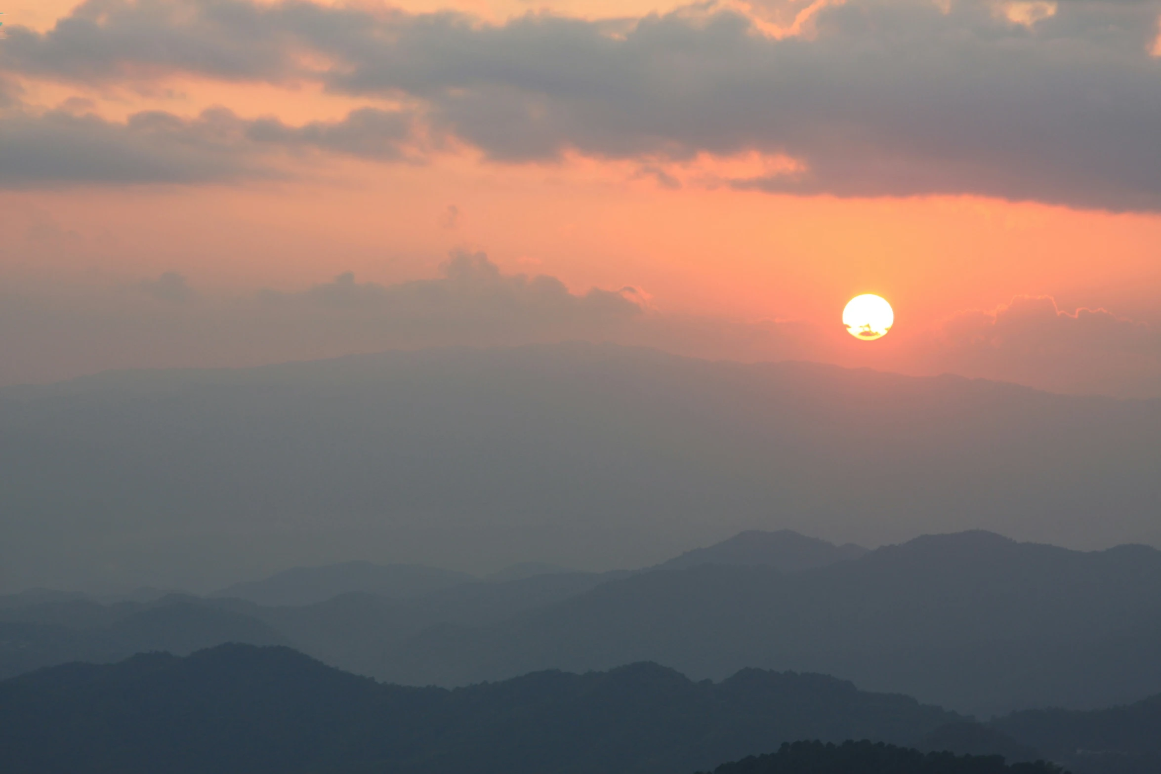 the sun setting over the mountains of an area