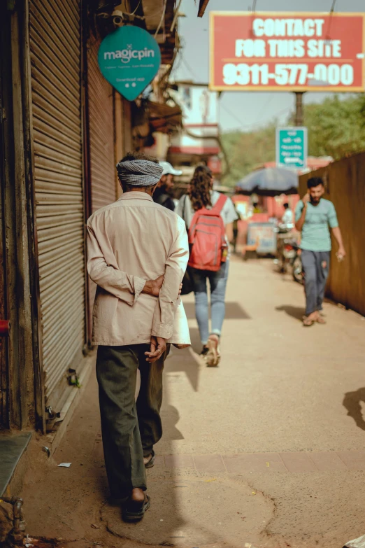 the man is walking down the street and there are people