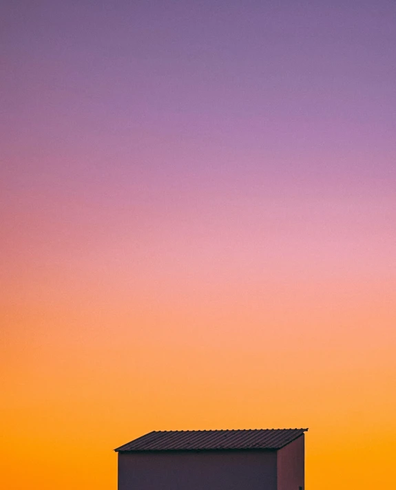 a plane flying high in the sky next to a house