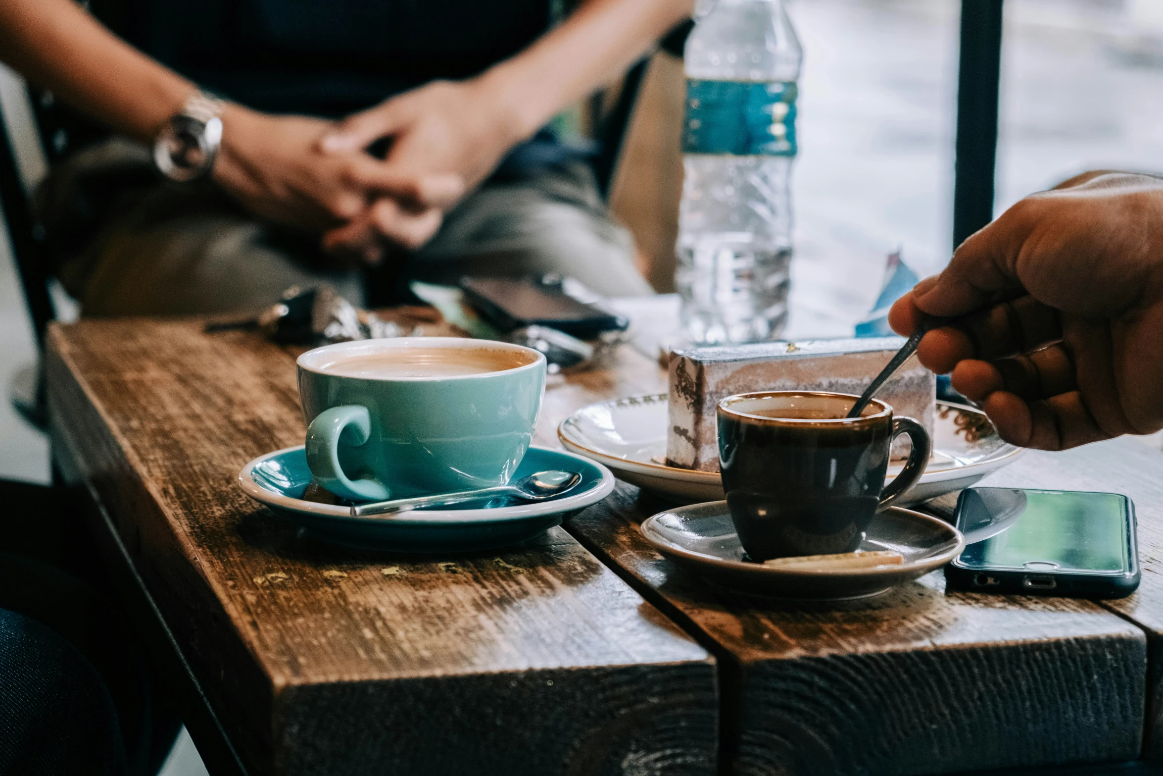 two people are eating in the cafe with a cup of coffee