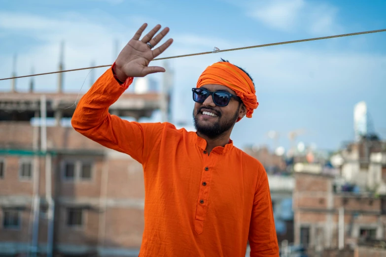 a man is wearing an orange turban on top of a hill