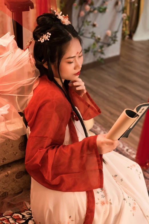 a woman is sitting with her hair down and reading the newspaper