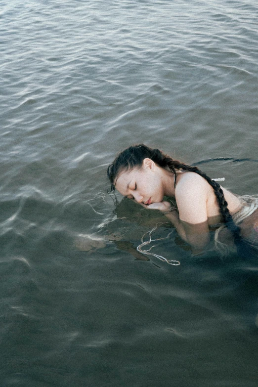 a woman laying on a surfboard in the water