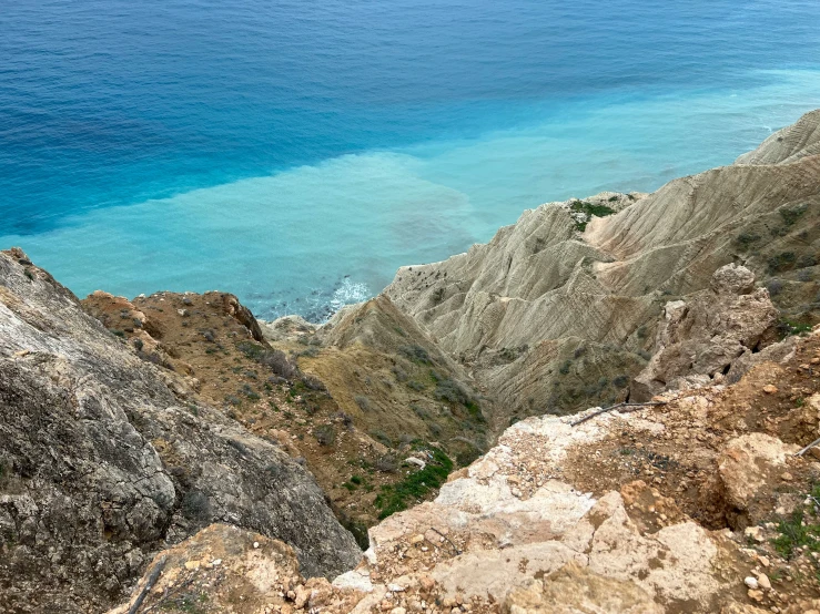 blue and white water near rocky cliff side