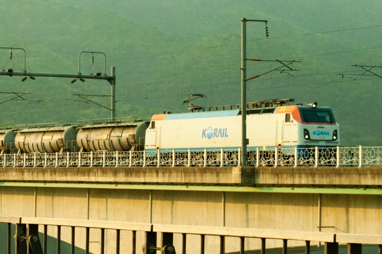 a train going across the bridge with another one standing on it