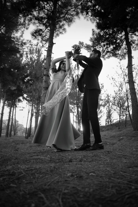 the bride and groom are posing in the forest