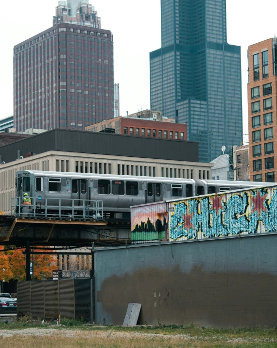 a train is on its track next to graffiti covered wall