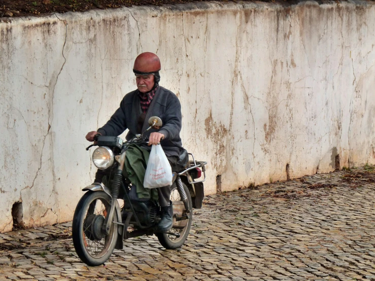 a man is riding on a motorcycle carrying his bags