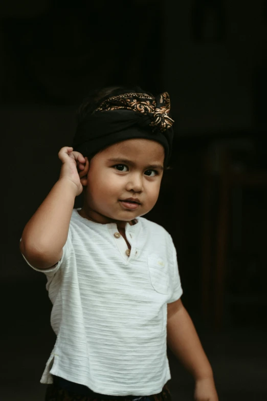 a little boy is wearing a black and white hat