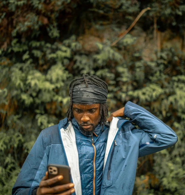 a man with his head bowed down looks at a cell phone