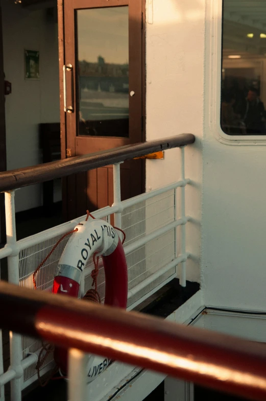 a white and red fire hydrant sitting on a red white railing