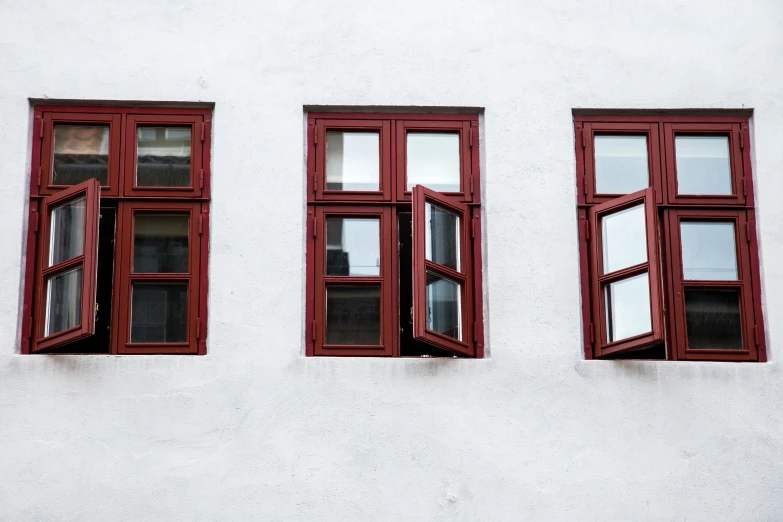 the windows on the white building have red panes