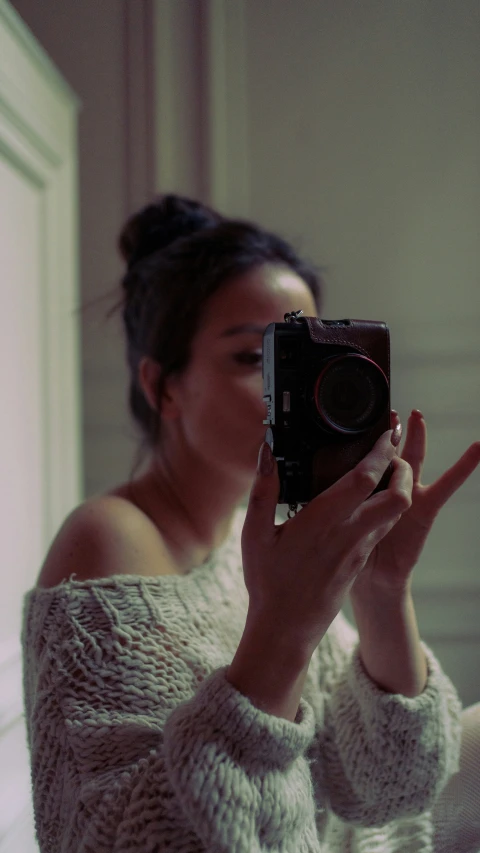 a young woman taking a po of her sweater