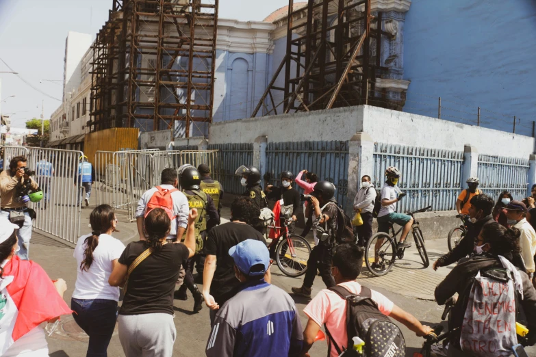 a crowd of people standing around on bikes near a building