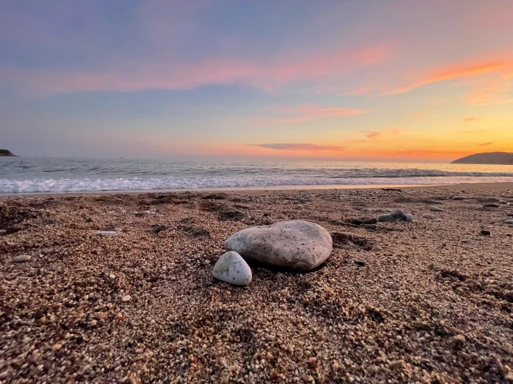 two rocks that are sitting on the beach