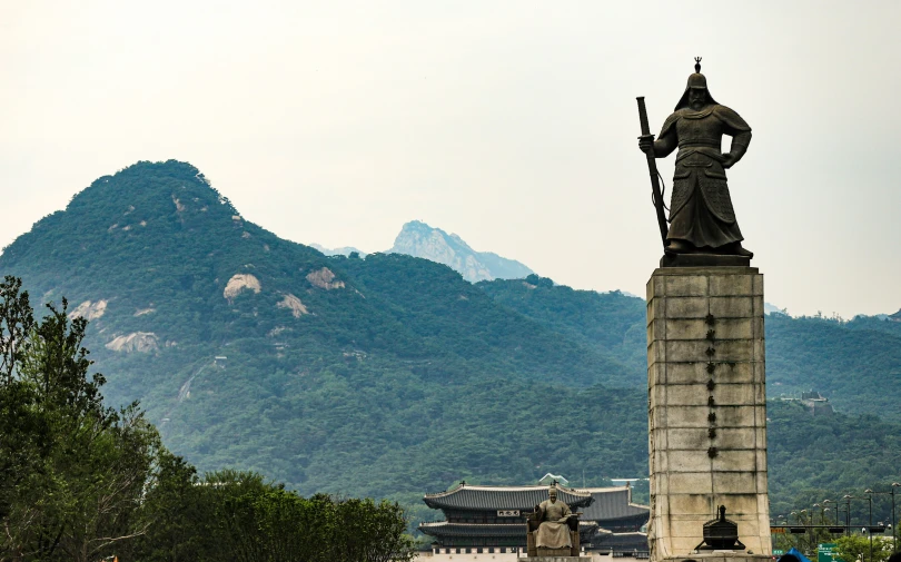 statue near the mountains on a cloudy day