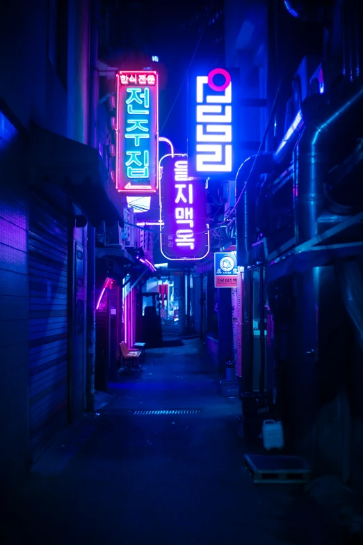 a dark alley with a lit up sign on the building