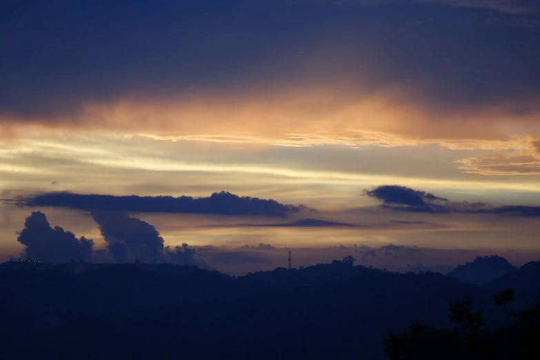 dark colored clouds on the horizon with mountains in the background