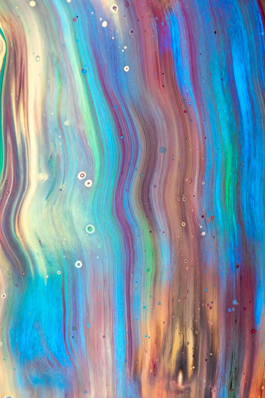 an abstract painting with colorful fluid paint pouring over the surface
