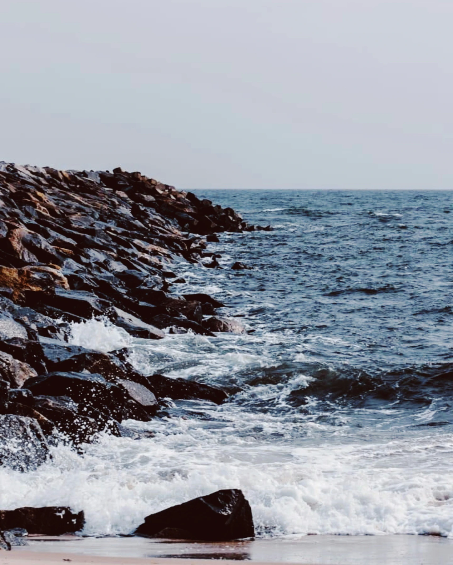 a view of rocks and the water in front of it