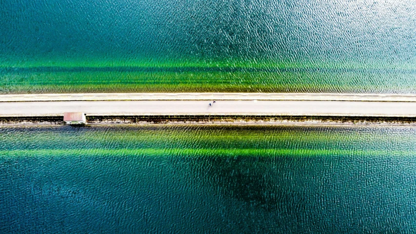 an aerial view of the outer part of an island with a road going to it