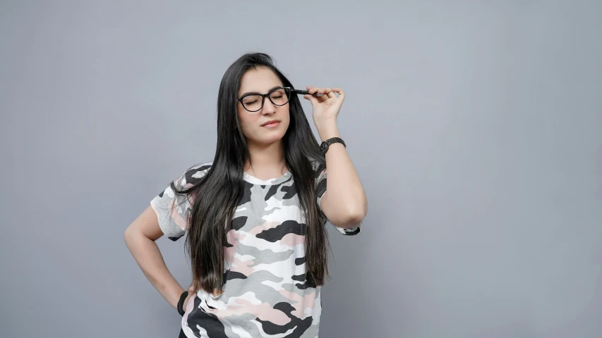 a girl with glasses holds her head up and looks away from the camera