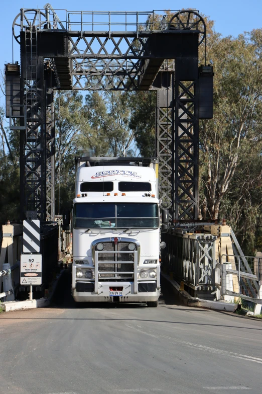 a big truck going over a bridge over a street