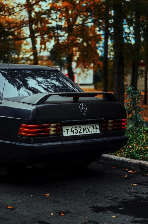 the back of a black mercedes benz - benz is parked on the street