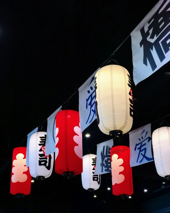 lanterns hanging from strings with asian writing and images on them