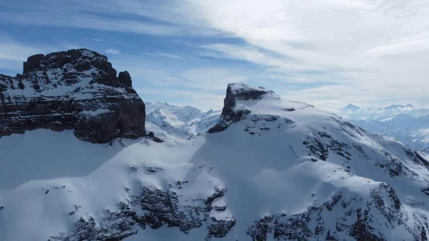 a snowy mountain scene with an ice filled cliff and snow covered rocks