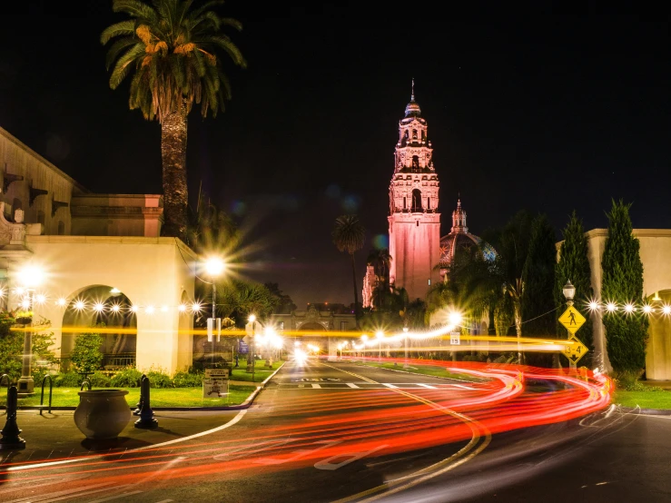 traffic is moving past a tall church at night