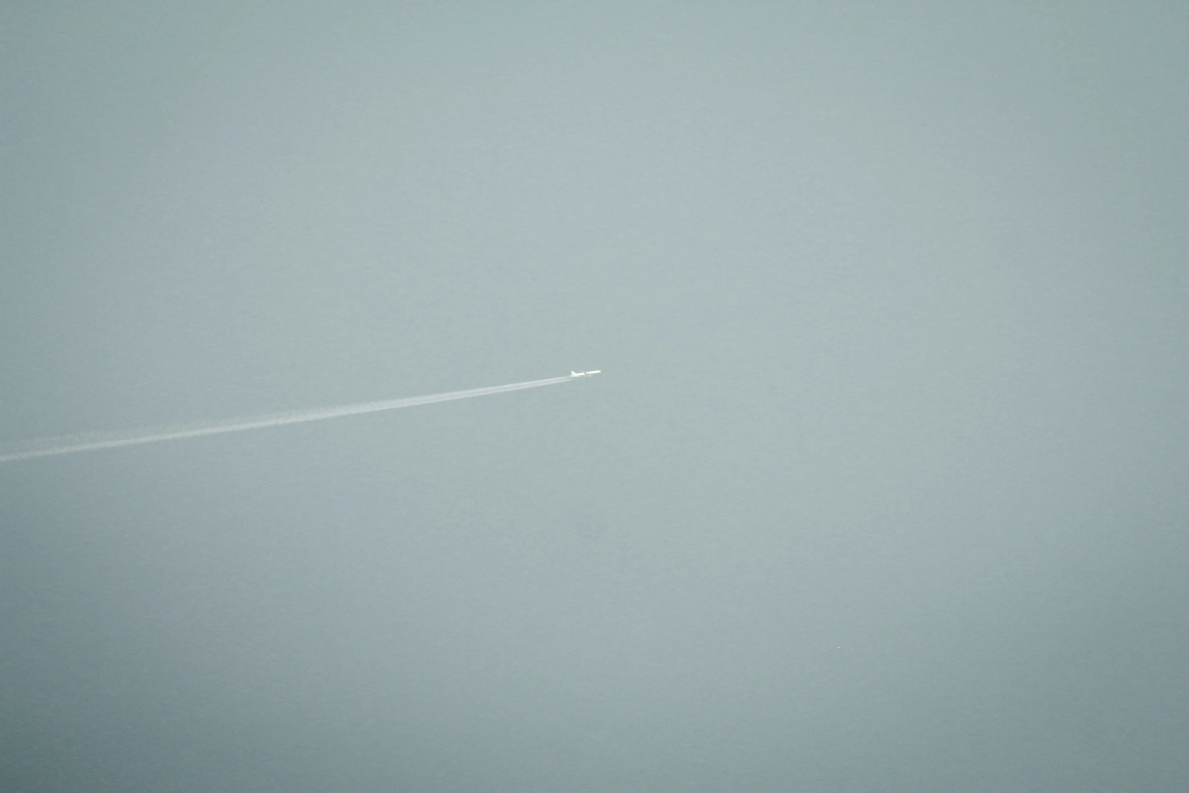 airplane flying over an airport in the fog