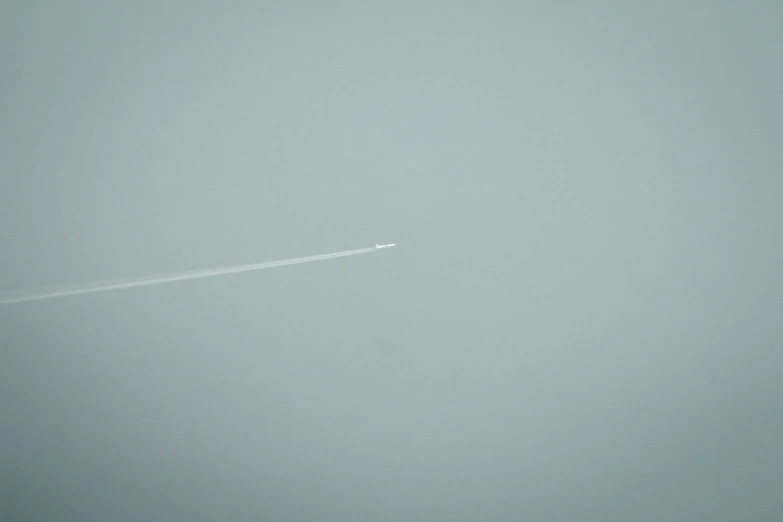 airplane flying over an airport in the fog