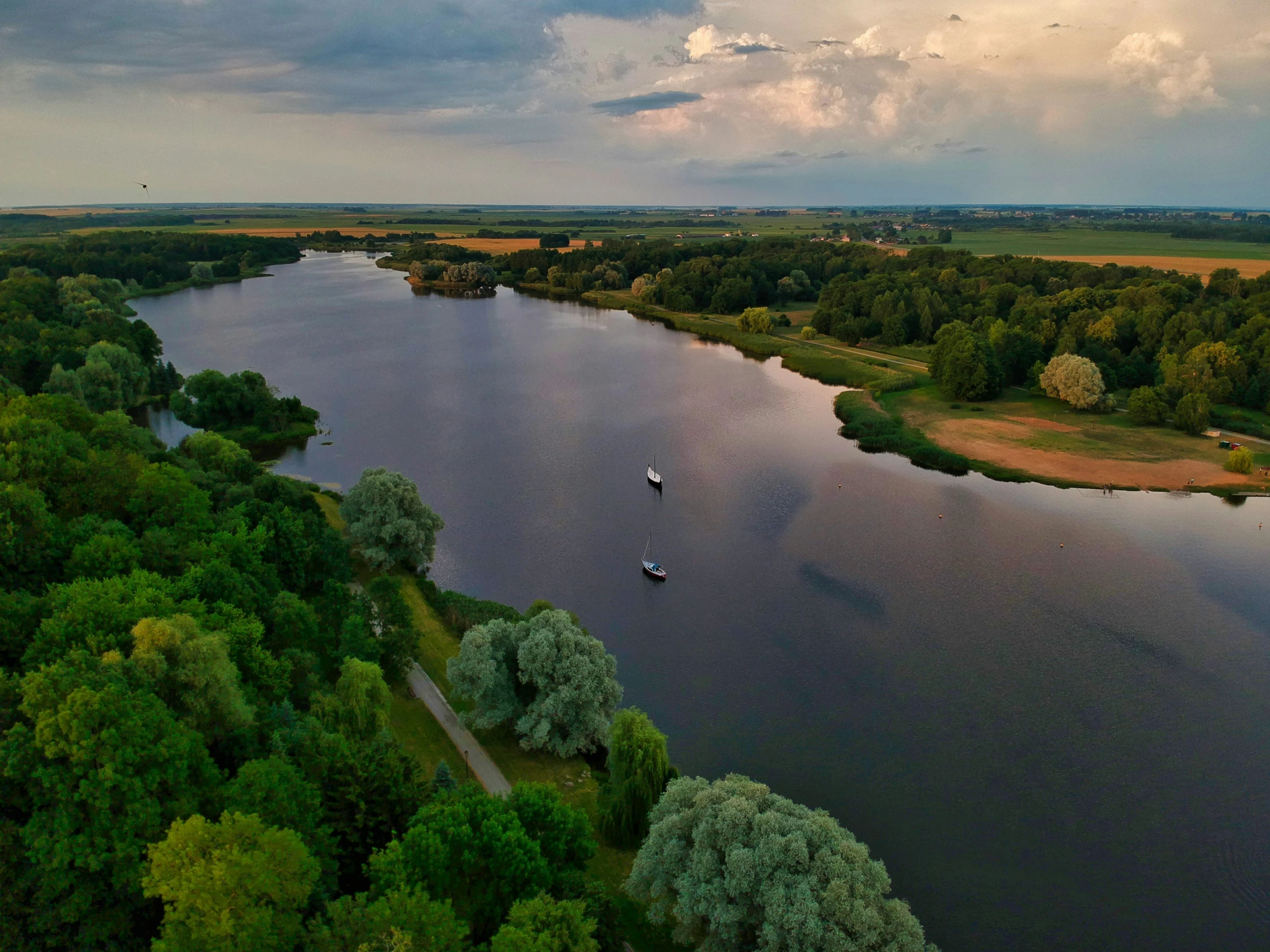 a view of trees, water, and a cloudy sky