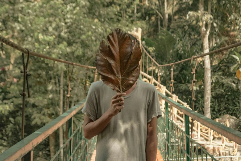 a person is holding leaves to their face