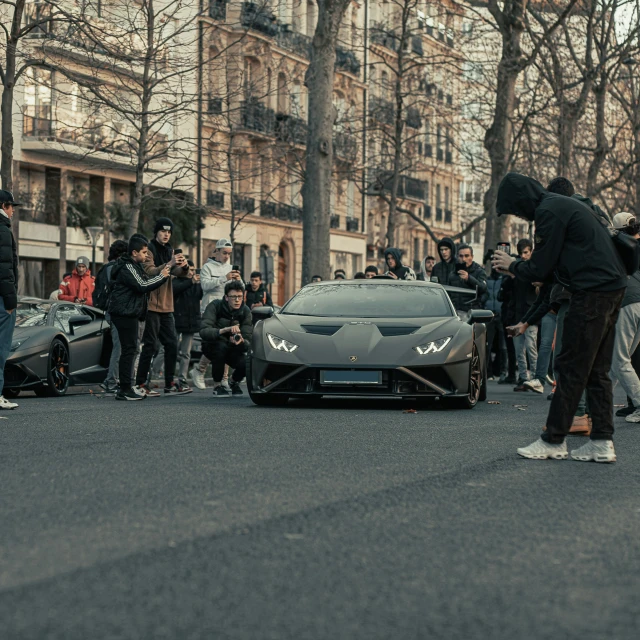 a man standing on the edge of a car in the street