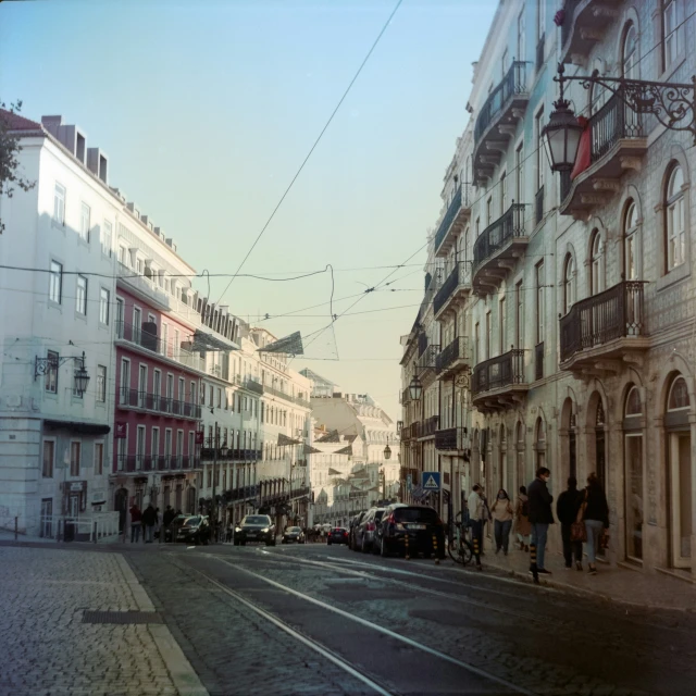 several people walk down an empty street in an old fashioned town