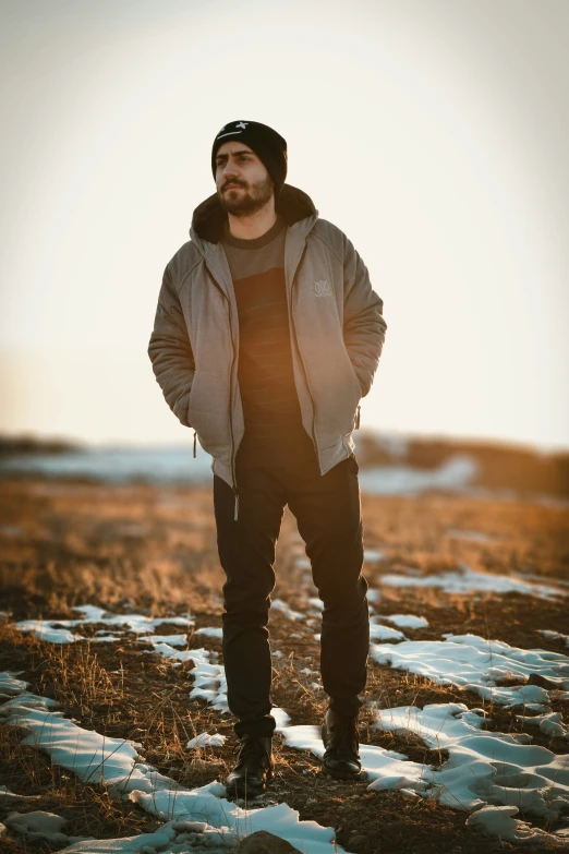 man with beard and beanie standing in a field