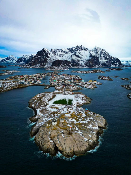 the small island is surrounded by snowy mountains