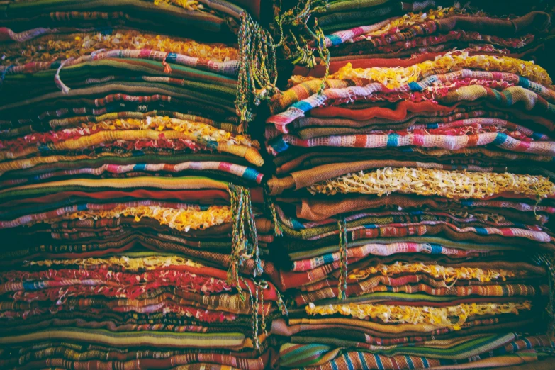 large pile of fabrics on sale at a market