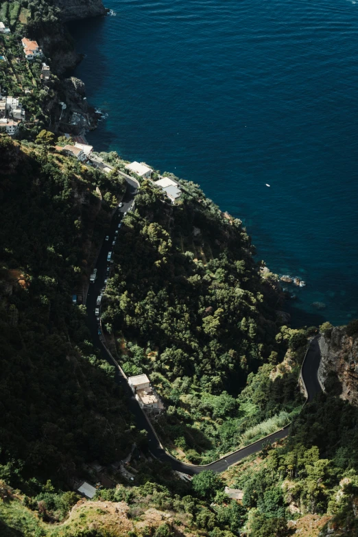 a winding road between two mountain sides is on the ocean shore