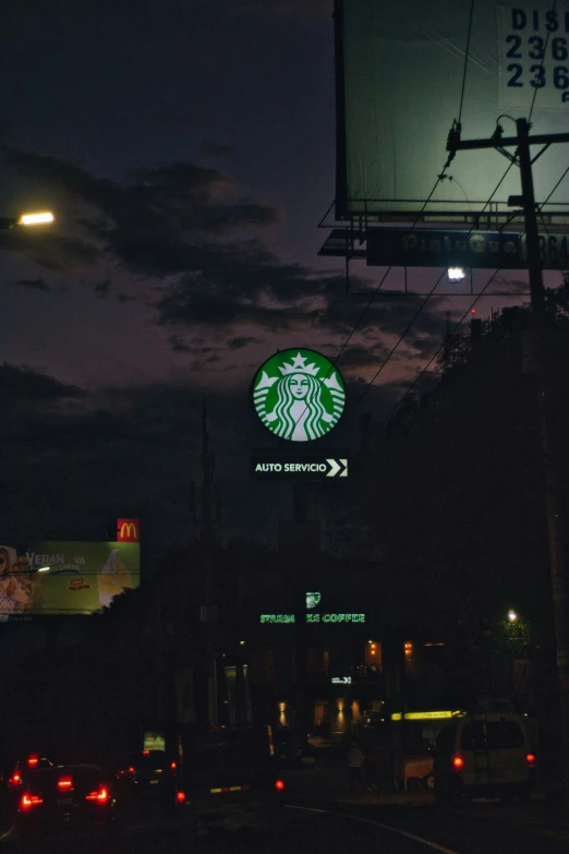 starbucks sign at night on the side of the street