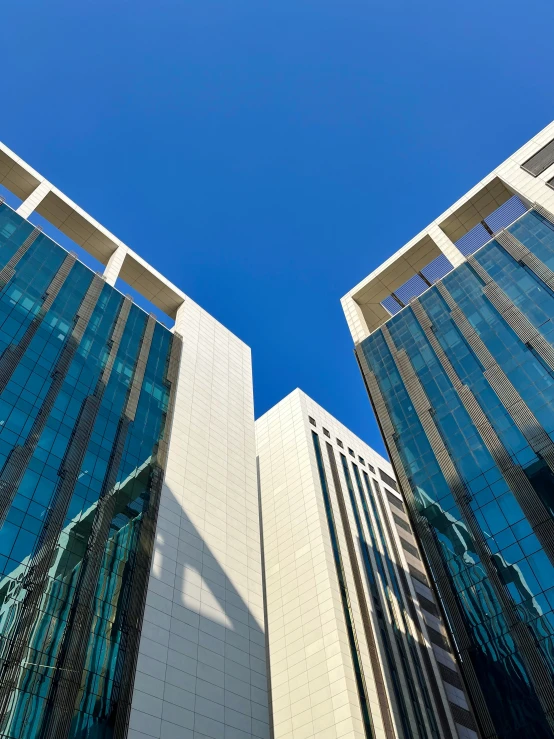 two tall buildings are against a blue sky